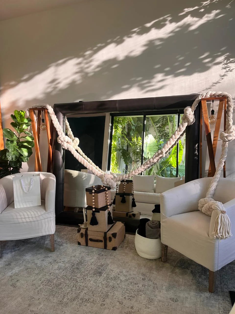 A composition of pale braids framing a sitting area with white armchairs and windows onto the garden.