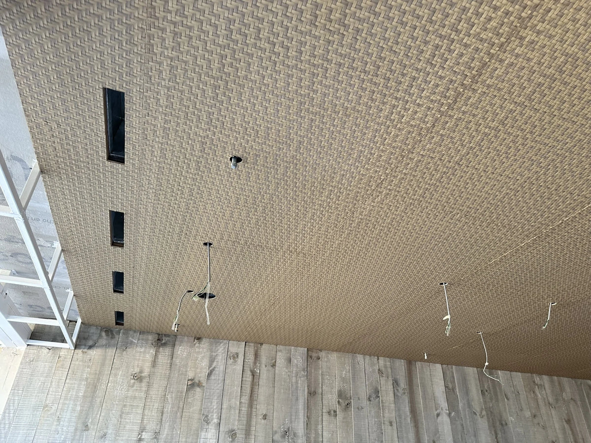 Wide view of the woven ceiling, with panel divisions and service outlets still visible.