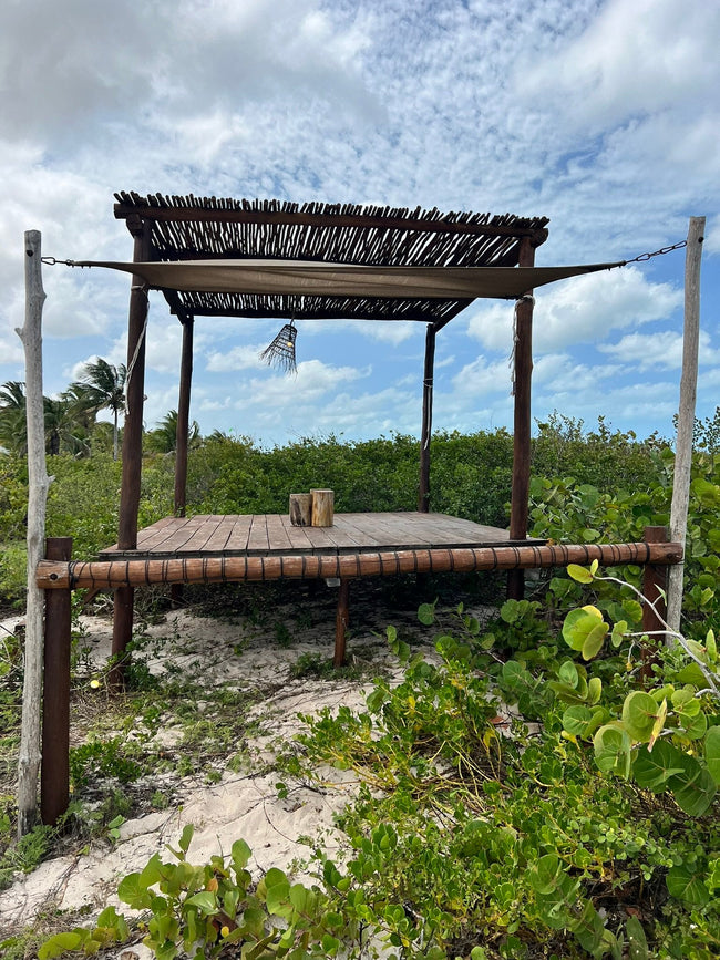 Vue extérieure d’une pergola et d’un filet de détente entourés de végétation côtière à Telchac.